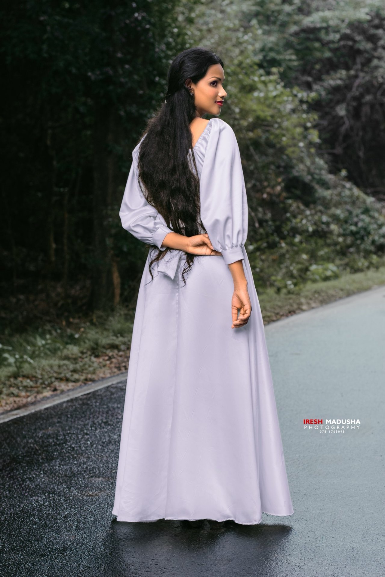 Elegant back portrait on rain-washed road