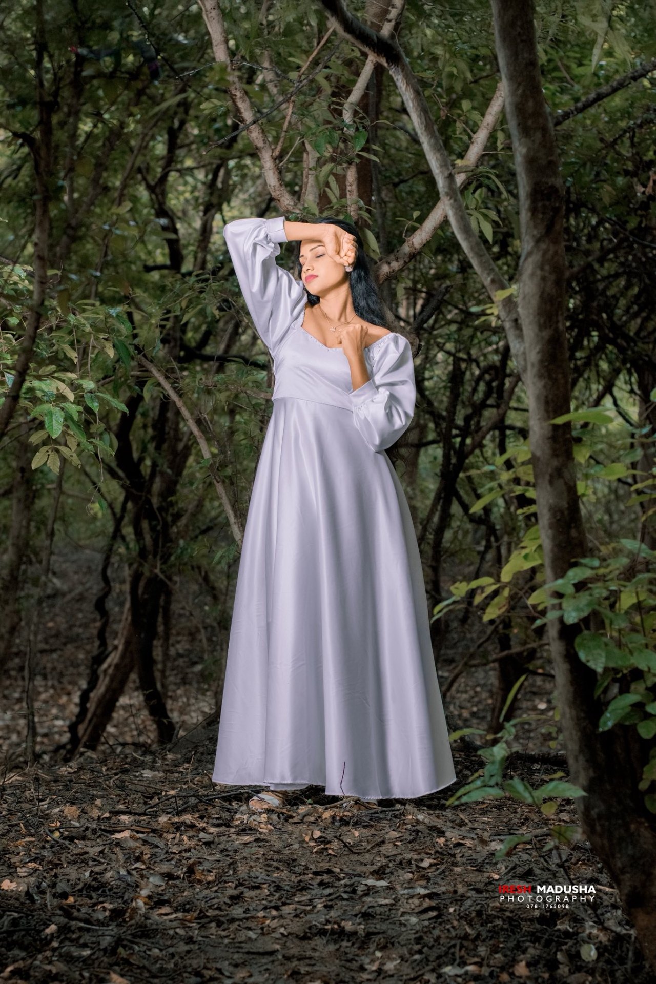Fashion model in elegant white gown — forest setting